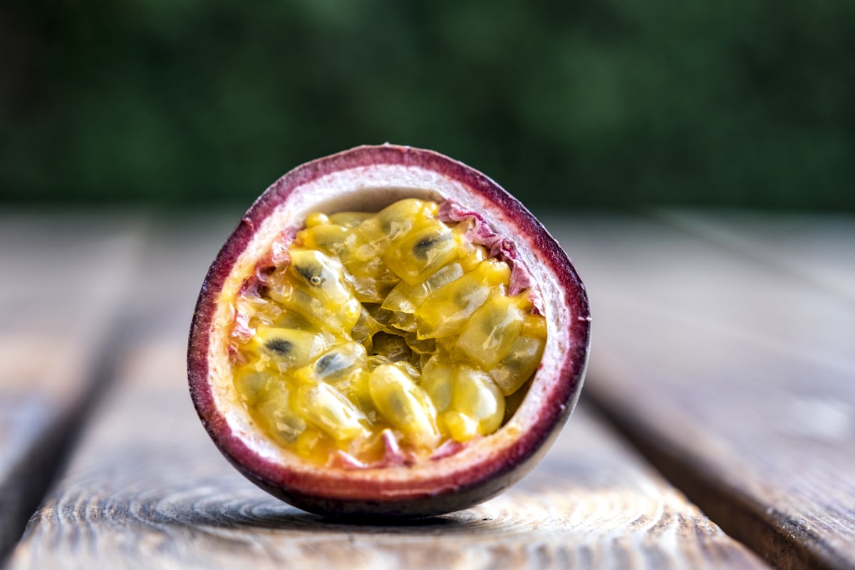 A halved purple passion fruit revealing golden seeded pulp